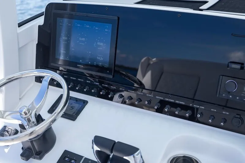 Slide: The Image of 2026 Sea Hunt Gamefish 27 Coffin Box dashboard with steering wheel and electronic controls. - 14