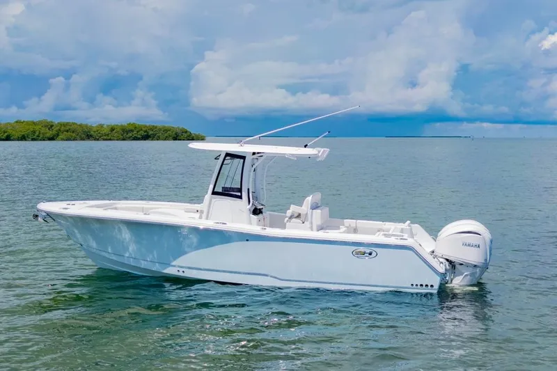 Slide: The Image of 2026 Sea Hunt Gamefish 27 Coffin Box boat on calm water under a cloudy sky. - 36