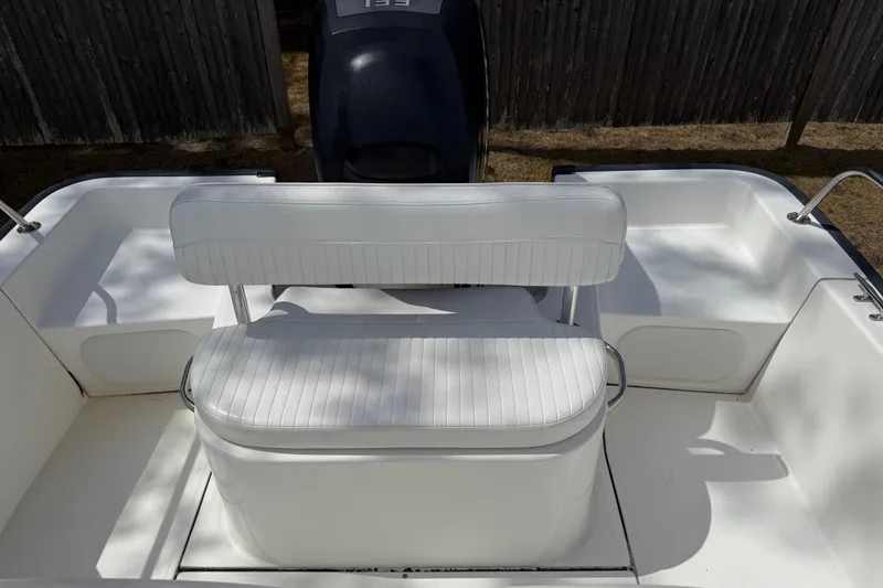 Slide: The Image of 2007 Boston Whaler 190 Montauk boat interior with white seating and motor. - 8
