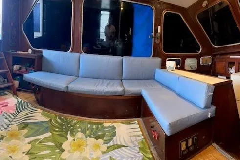 Slide: The Image of 1979 Sun Harbor Sundeck Trawler interior with blue seating and floral rug. - 10