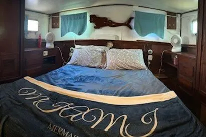 Slide: The Image of 1979 Sun Harbor Sundeck Trawler bedroom with nautical decor and cozy bedding. - 11