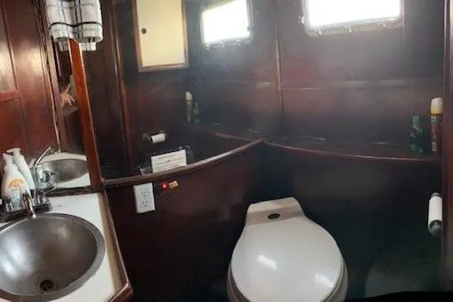 Slide: The Image of 1979 Sun Harbor Sundeck Trawler bathroom with wooden interior, sink, and toilet. - 12