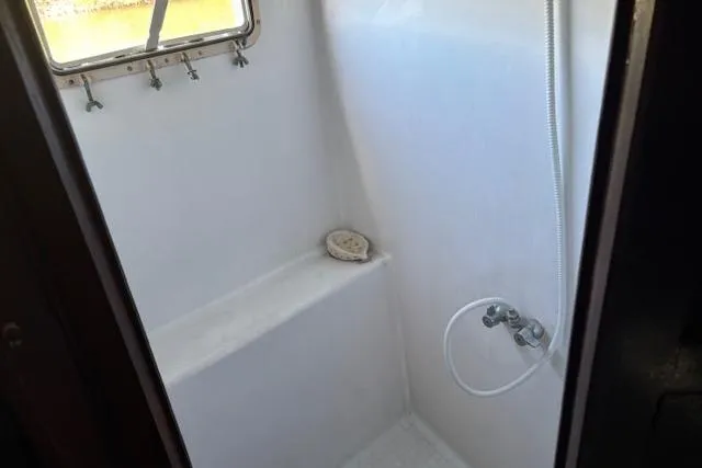 Slide: The Image of 1979 Custom Sun Harbor Sundeck Trawler shower with window and white interior. - 14
