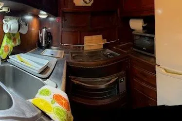 Slide: The Image of 1979 Sun Harbor Sundeck Trawler kitchen with sink, stove, and wooden cabinetry. - 17