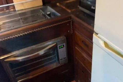 Slide: The Image of 1979 Sun Harbor Sundeck Trawler kitchen with stove and wooden cabinetry. - 18