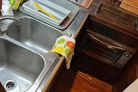 Slide: The Image of 1979 Sun Harbor Sundeck Trawler kitchen with double sink and citrus-themed towel. - 19