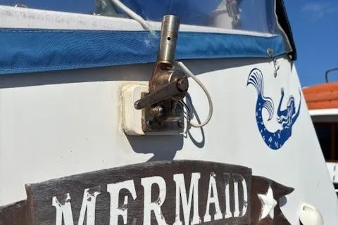 Slide: The Image of 1979 Custom Sun Harbor Sundeck Trawler with "Mermaid" sign and nautical design. - 2