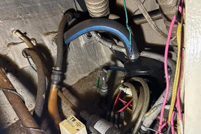 Slide: The Image of Engine compartment of a 1979 Custom Sun Harbor Sundeck Trawler with various hoses and wiring. - 22