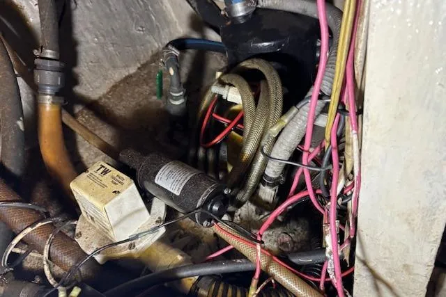 Slide: The Image of Engine compartment of 1979 Custom Sun Harbor Sundeck Trawler with wiring and hoses. - 23