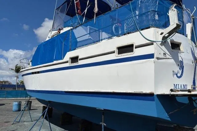 Slide: The Image of 1979 Custom Sun Harbor Sundeck Trawler on dry dock in Miami, featuring blue and white design. - 30