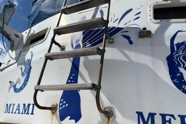 Slide: The Image of Vintage 1979 Custom Sun Harbor Sundeck Trawler with mermaid artwork and ladder, docked in Miami. - 32
