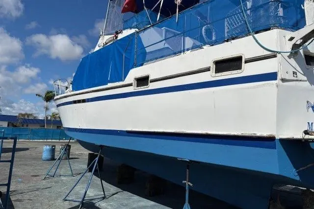 Slide: The Image of 1979 Custom Sun Harbor Sundeck Trawler on dry dock, blue and white exterior, clear sky. - 36