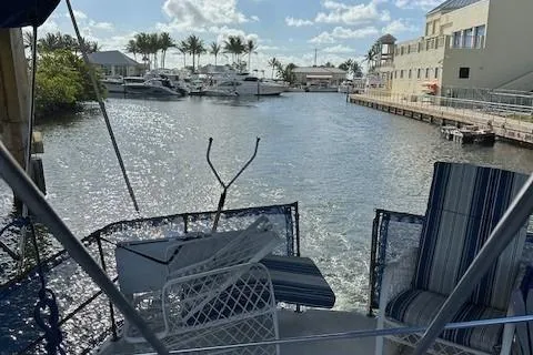 Slide: The Image of 1979 Sun Harbor Sundeck Trawler docked in a scenic marina with palm trees and buildings. - 5