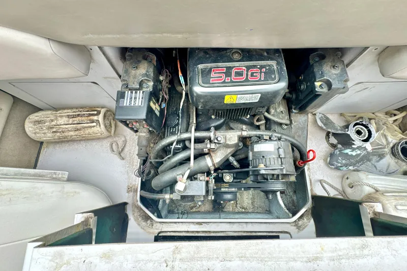Slide: The Image of Engine compartment of a 1999 Four Winns 220 Horizon boat, featuring a 5.0 Gi engine. - 2