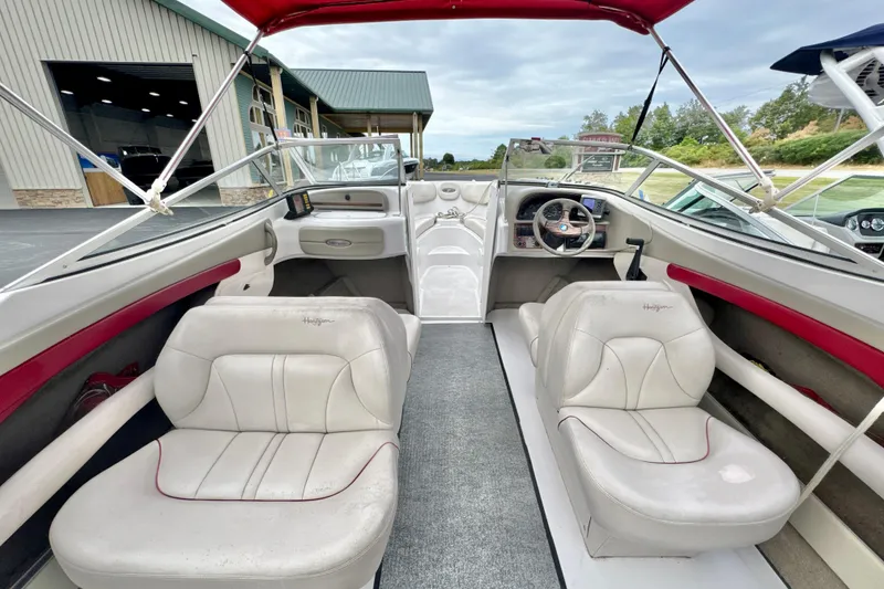 Slide: The Image of 1999 Four Winns 220 Horizon boat interior with white seating and red accents. - 7