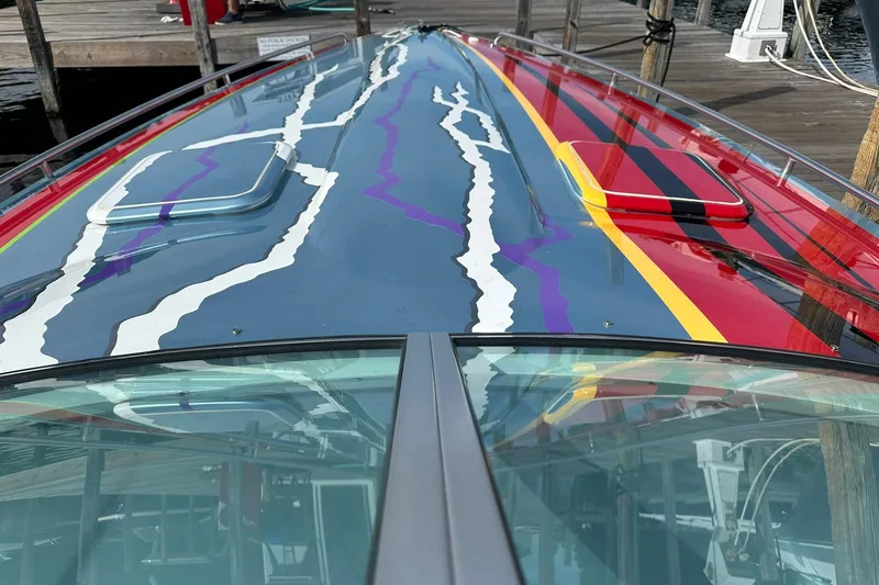 Slide: The Image of 2008 Formula 292 FASTech boat with vibrant, colorful deck design at a dock. - 10