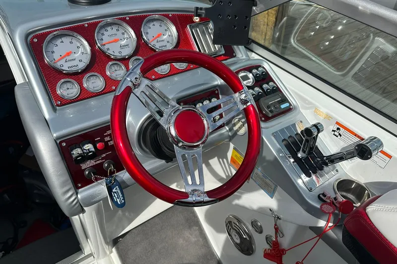 Slide: The Image of 2008 Formula 292 FASTech boat dashboard with red steering wheel and gauges. - 9