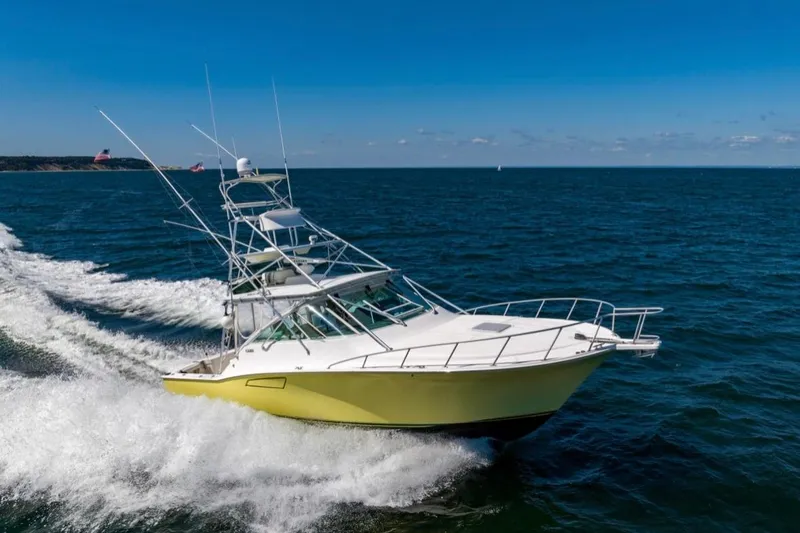 Slide: The Image of 2005 Cabo 40 Express yacht on open sea under clear blue sky. - 2