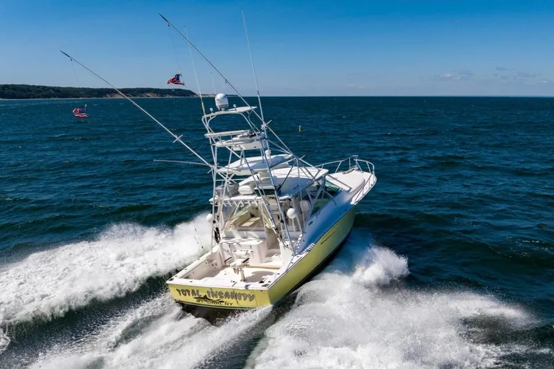 Slide: The Image of 2005 Cabo 40 Express yacht cruising on open sea under clear blue sky. - 3