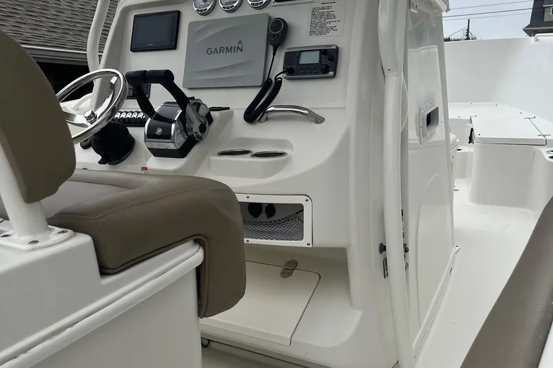 Slide: The Image of 2013 Sailfish 270 CC boat cockpit with Garmin navigation system and beige seating. - 19