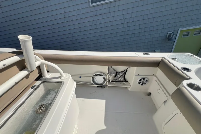 Slide: The Image of 2013 Sailfish 270 CC boat interior with storage, rod holder, and speaker. - 24
