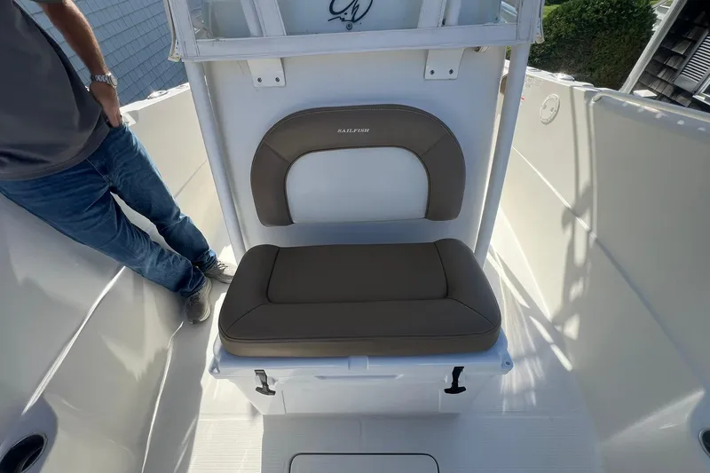 Slide: The Image of 2013 Sailfish 270 CC boat interior with cushioned seating and person standing nearby. - 28