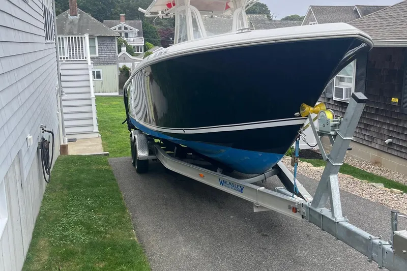 Slide: The Image of 2013 Sailfish 270 CC boat on trailer, parked between houses. - 6