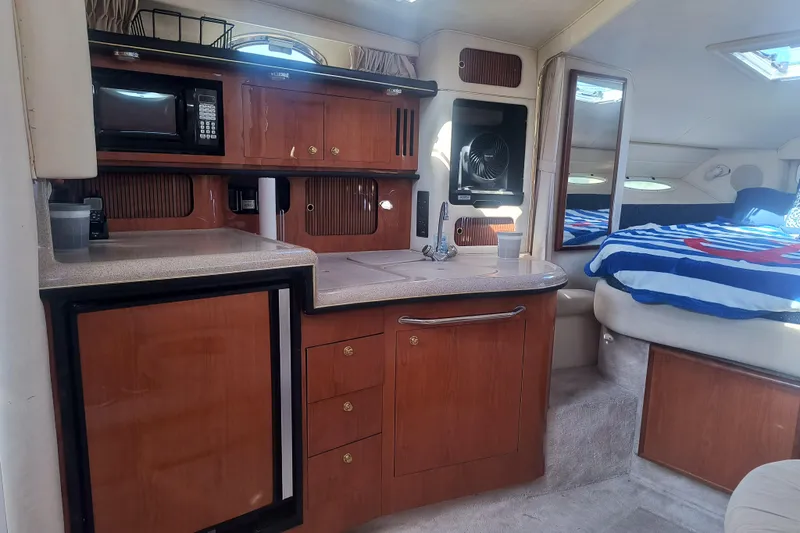 Slide: The Image of Interior of 2000 Sea Ray 340 Sundancer with kitchenette and cozy sleeping area. - 11