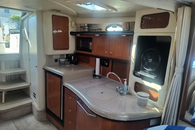 Slide: The Image of Interior of 2000 Sea Ray 340 Sundancer yacht with kitchenette and modern amenities. - 12