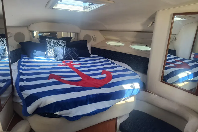 Slide: The Image of Cozy cabin interior of 2000 Sea Ray 340 Sundancer with nautical-themed bedding. - 13