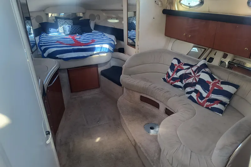 Slide: The Image of Interior of 2000 Sea Ray 340 Sundancer with nautical-themed decor and cozy seating. - 8