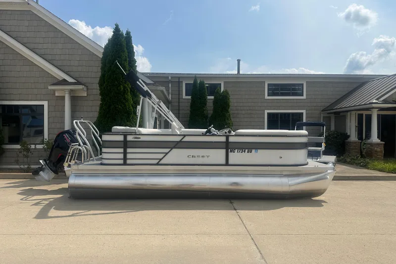The Image of 2022 Crest Classic LX 200 pontoon boat parked outside a building. - 1
