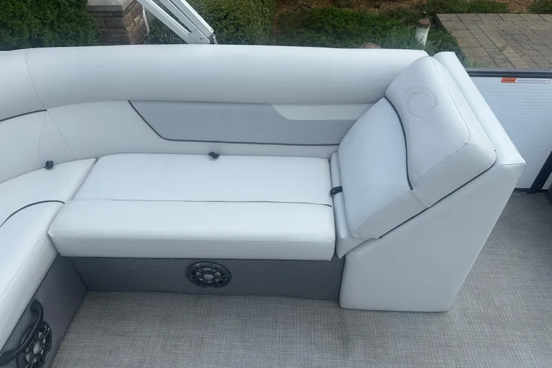 Slide: The Image of 2022 Crest Classic LX 200 boat interior with white cushioned seating and speaker. - 15