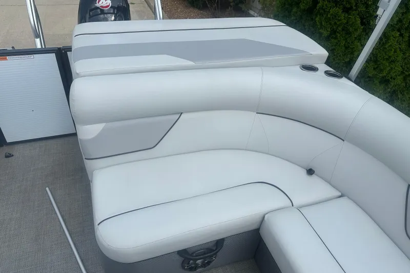 Slide: The Image of 2022 Crest Classic LX 200 boat interior with white cushioned seating and cup holders. - 16