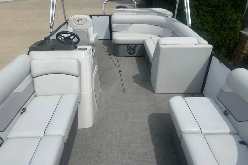 Slide: The Image of 2022 Crest Classic LX 200 pontoon boat interior with plush seating and steering console. - 3