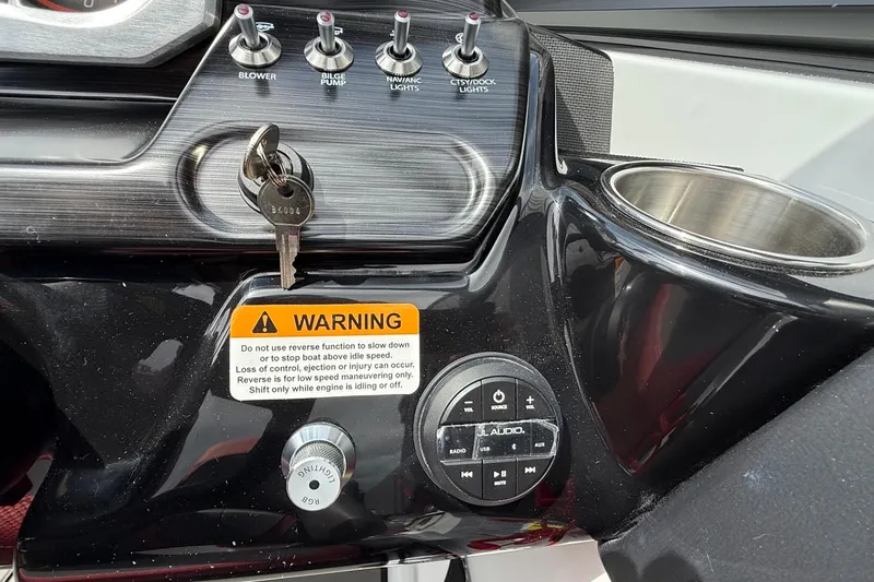 Slide: The Image of Dashboard of 2026 Scarab 195 LX boat with controls, warning label, and cup holder. - 14