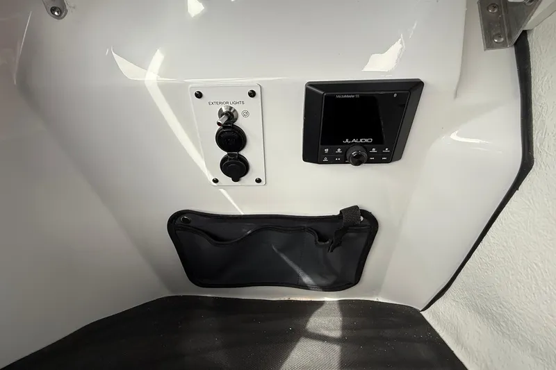 Slide: The Image of Control panel of 2026 Scarab 195 LX boat with audio system and exterior light switch. - 16