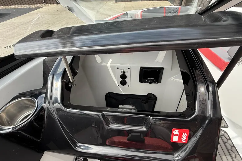 Slide: The Image of 2026 Scarab 195 LX boat interior with storage compartment and audio controls. - 17