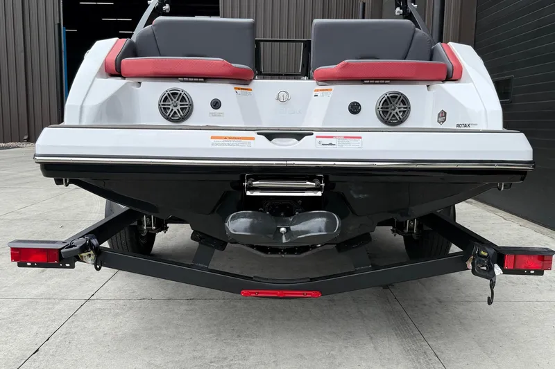 Slide: The Image of Rear view of 2026 Scarab 195 LX boat on trailer, showcasing sleek design and speakers. - 2