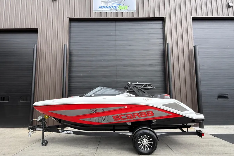 Slide: The Image of 2026 Scarab 195 LX boat in red and white, parked outside a garage. - 31