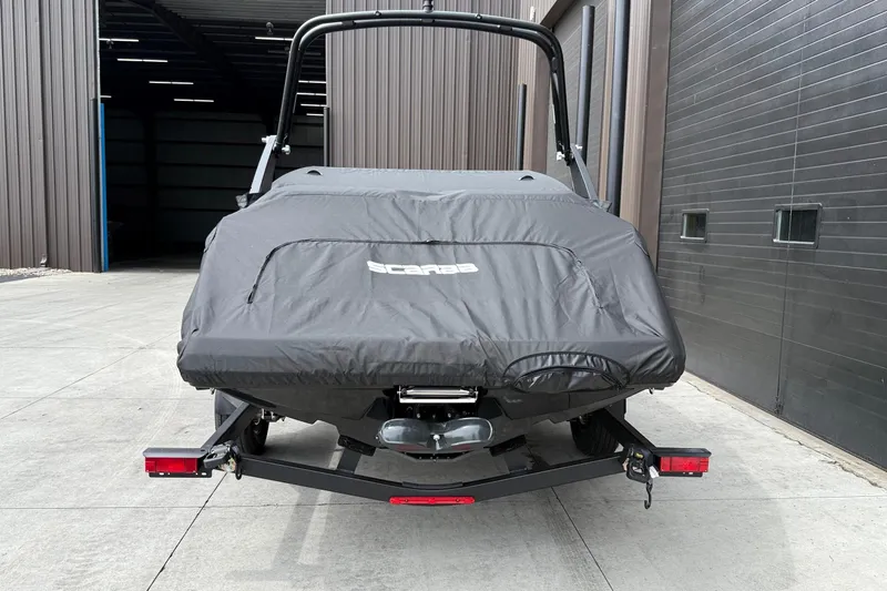 Slide: The Image of 2026 Scarab 195 LX boat covered, parked outside a garage. - 33