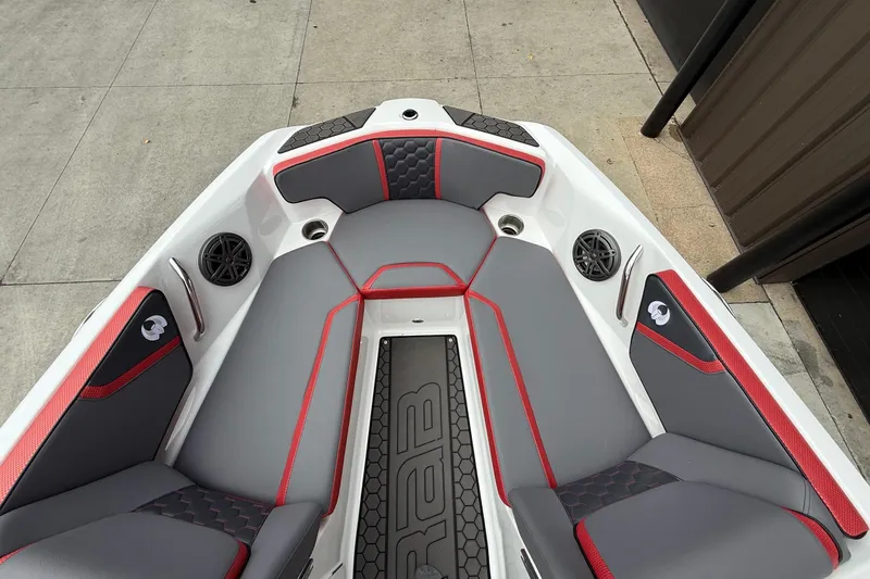 Slide: The Image of 2026 Scarab 195 LX boat interior with gray and red seating, speakers, and modern design. - 5