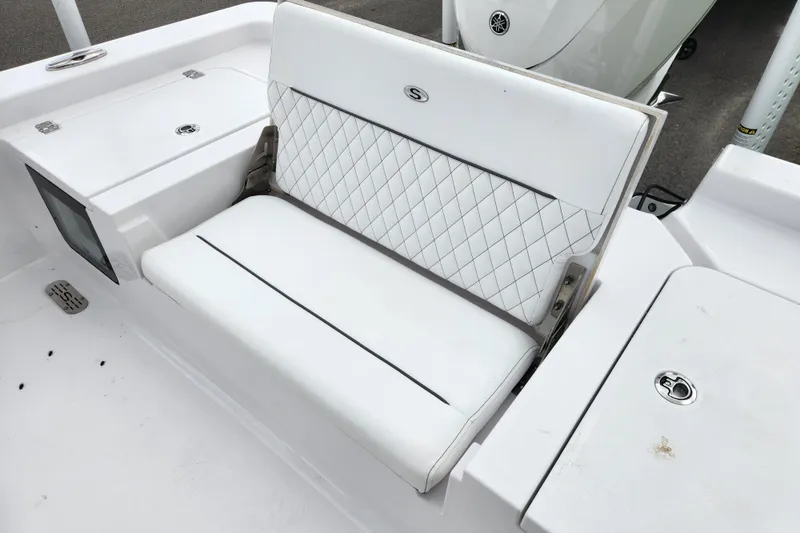 Slide: The Image of 2025 Sportsman Masters 247OE Bay Boat with white cushioned seating and storage compartments. - 22
