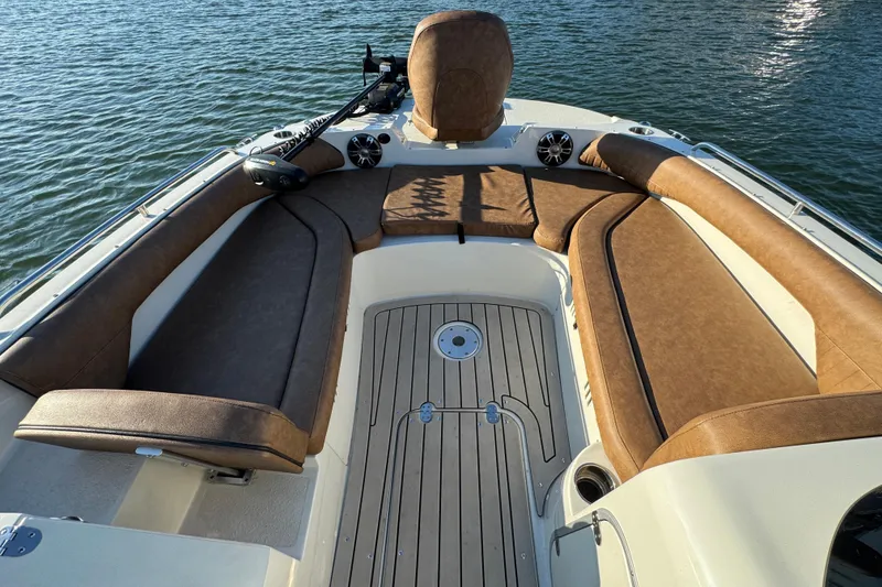 Slide: The Image of 2021 Stingray 192 SC boat interior with brown seating and wood-style flooring on water. - 10