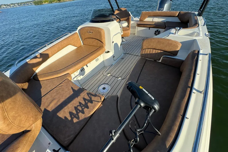 Slide: The Image of 2021 Stingray 192 SC boat interior with brown seating, on a calm lake. - 13