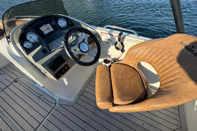 Slide: The Image of 2021 Stingray 192 SC boat cockpit with steering wheel and brown leather seat. - 16