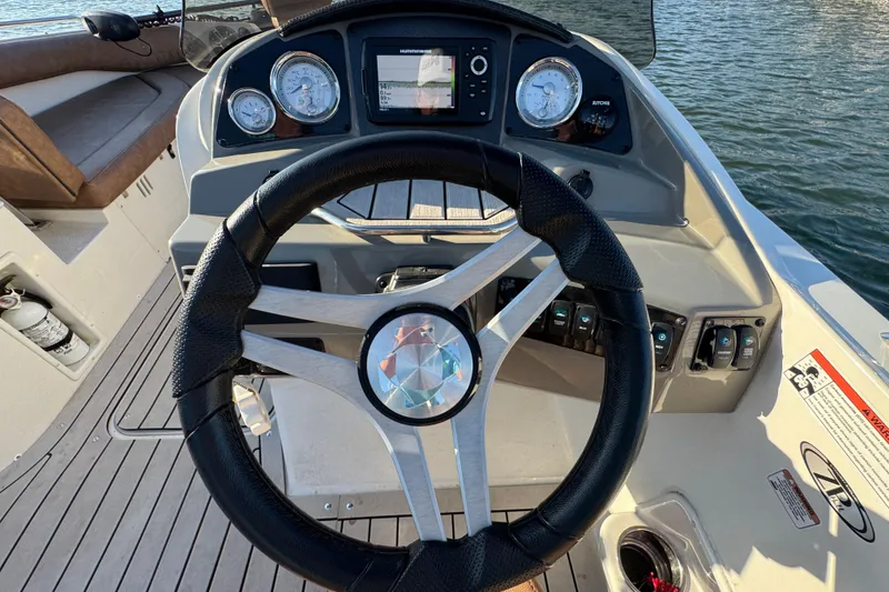 Slide: The Image of Steering wheel and dashboard of 2021 Stingray 192 SC boat on water. - 17