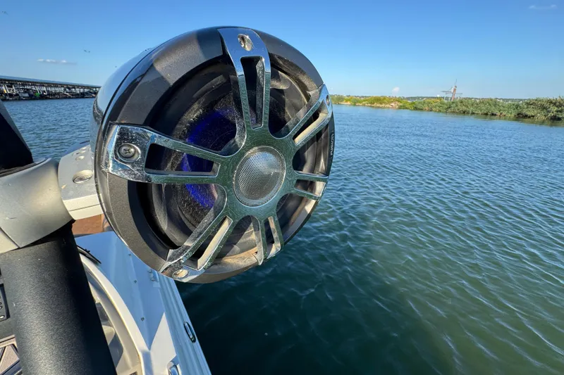 Slide: The Image of Close-up of a speaker on a 2021 Stingray 192 SC boat by the water. - 30