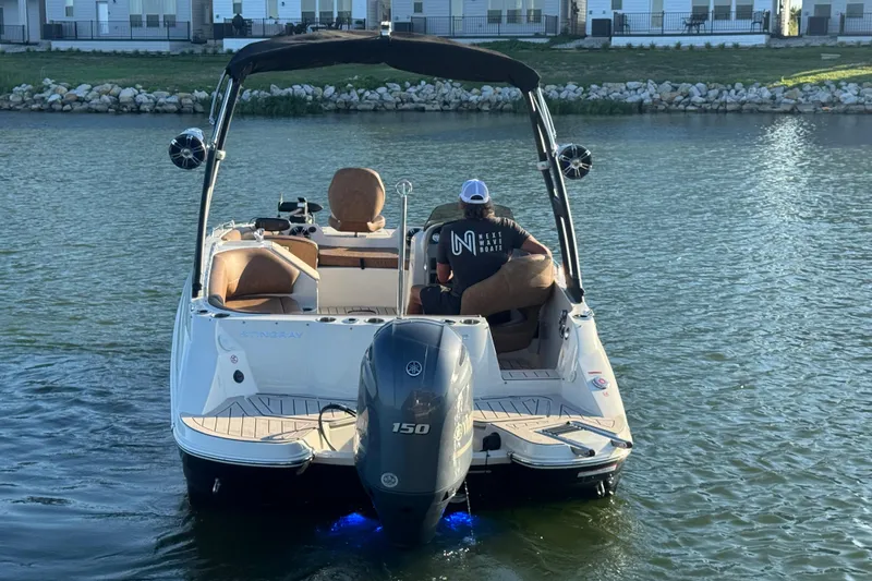 Slide: The Image of 2021 Stingray 192 SC boat on water, rear view with outboard motor and canopy. - 5