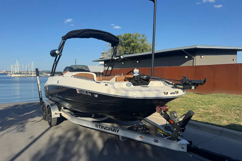 Slide: The Image of 2021 Stingray 192 SC boat on trailer by waterfront, clear sky background. - 7